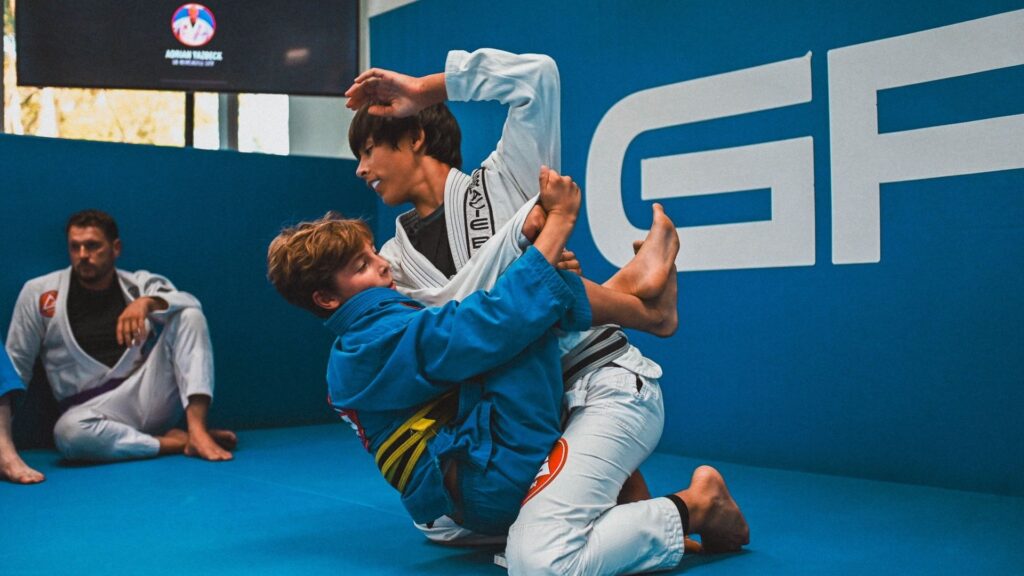 Young Brazilian Jiu-Jitsu students practising techniques during a Gracie Barra Kids class in Frenchs Forest.