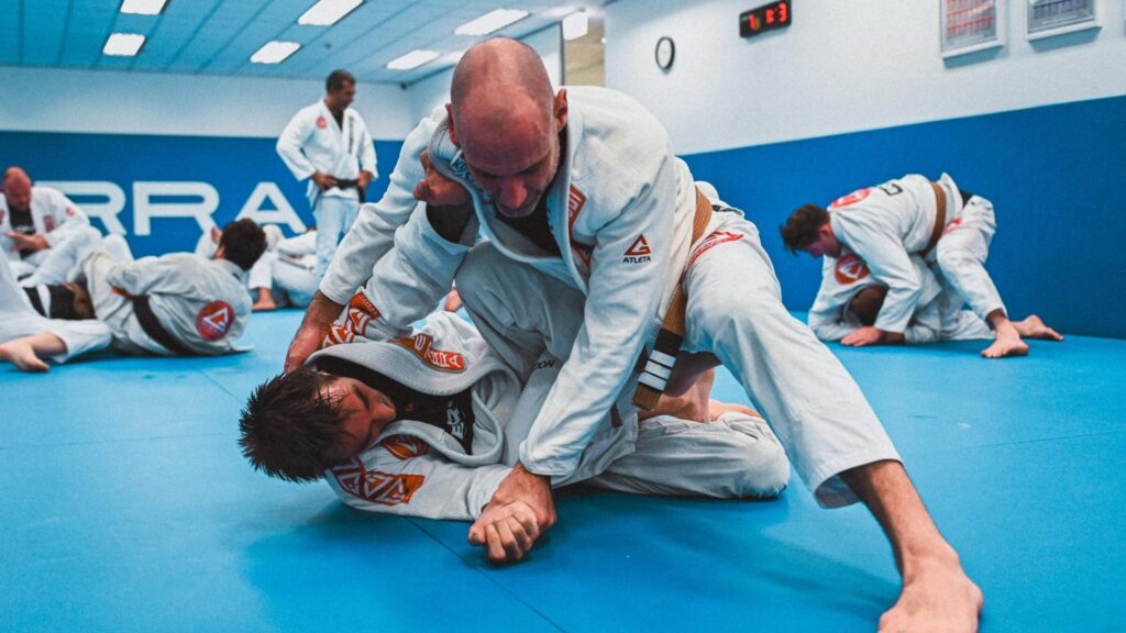 Adult Brazilian Jiu-Jitsu students practising positional training during a Gracie Barra class at Gracie Barra HQ Sydney in Frenchs Forest.