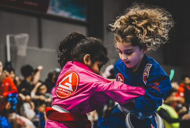 Two children in Gracie Barra gear performing Jiu-Jitsu