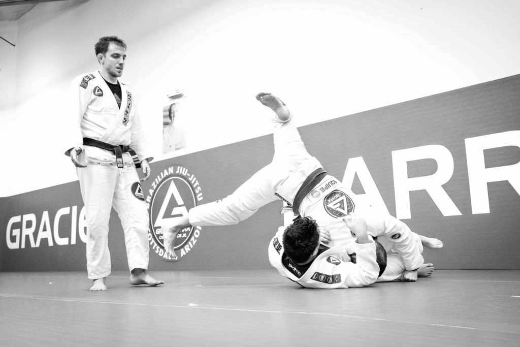 Students practicing jiu jitsu on the mat