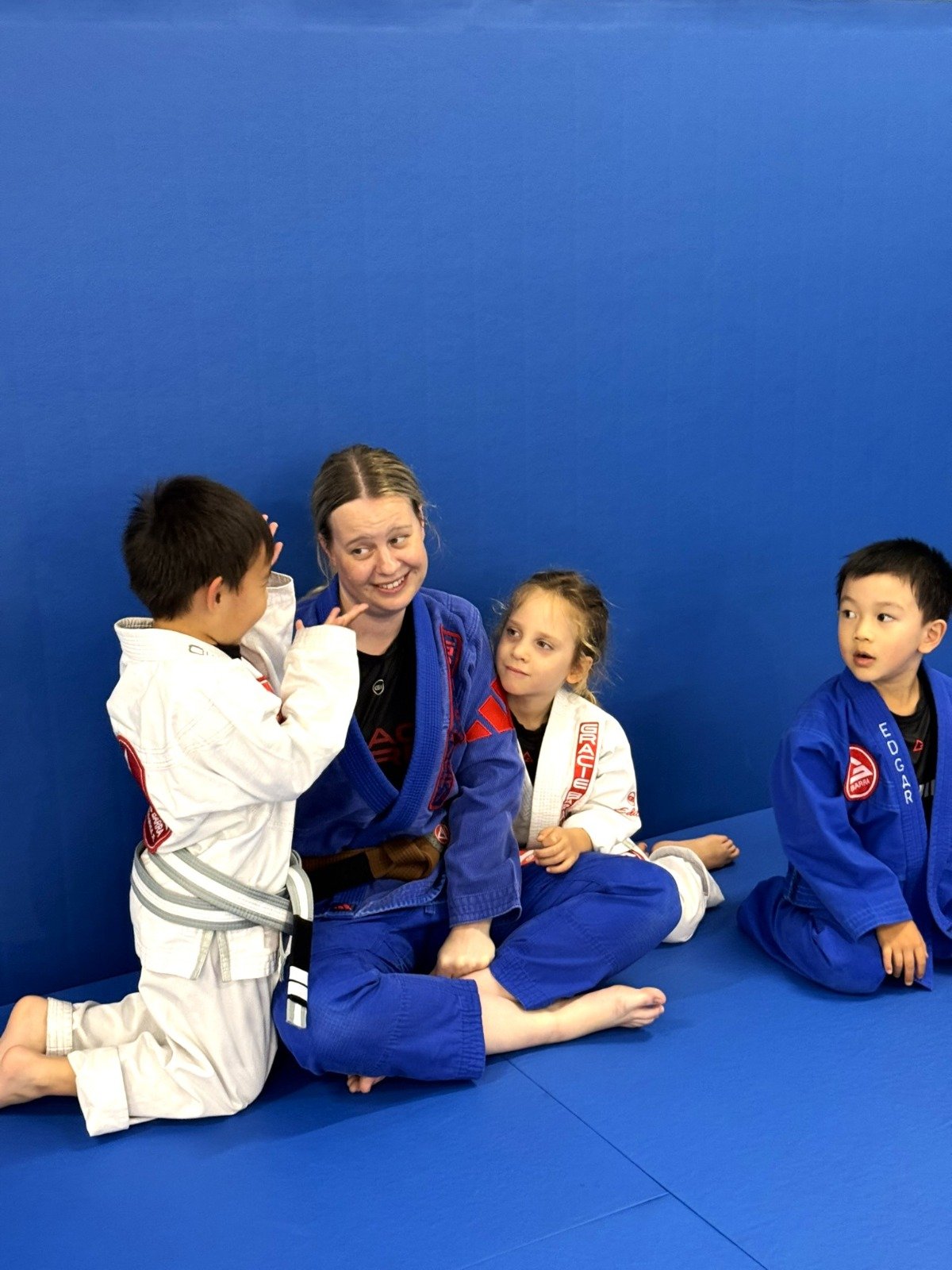 Instructor interacting with 5 and 6 year old kids during BJJ class at Gracie Barra Artarmon