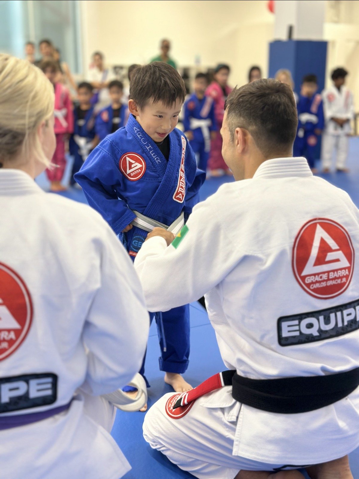 Children receiving belt promotions during kids BJJ class at Gracie Barra Artarmon