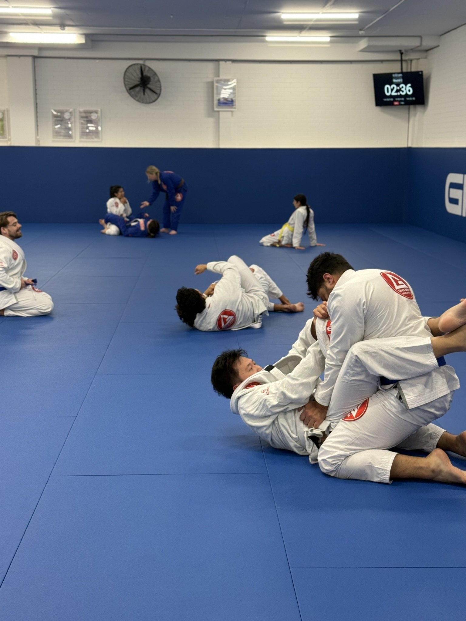 Adult students connecting through Brazilian Jiu-Jitsu training at Gracie Barra Artarmon