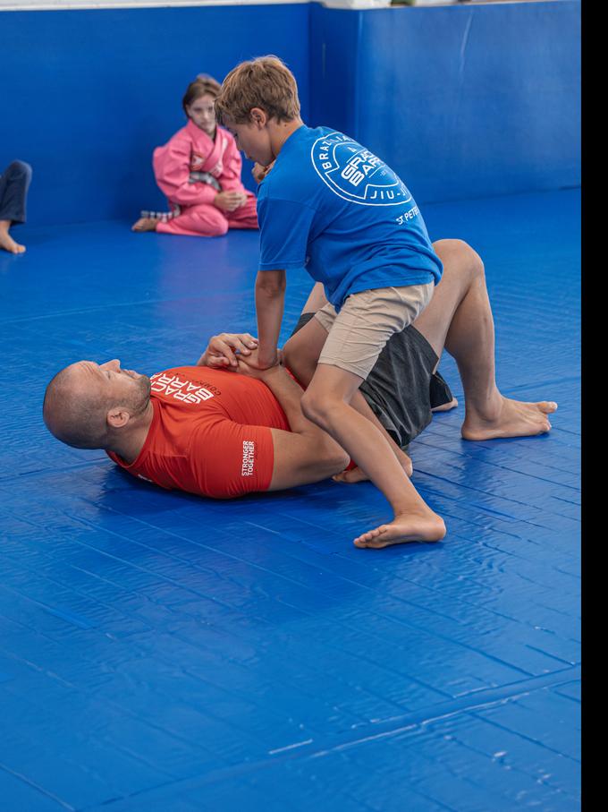 A coach working one on one with a young student while the group watches