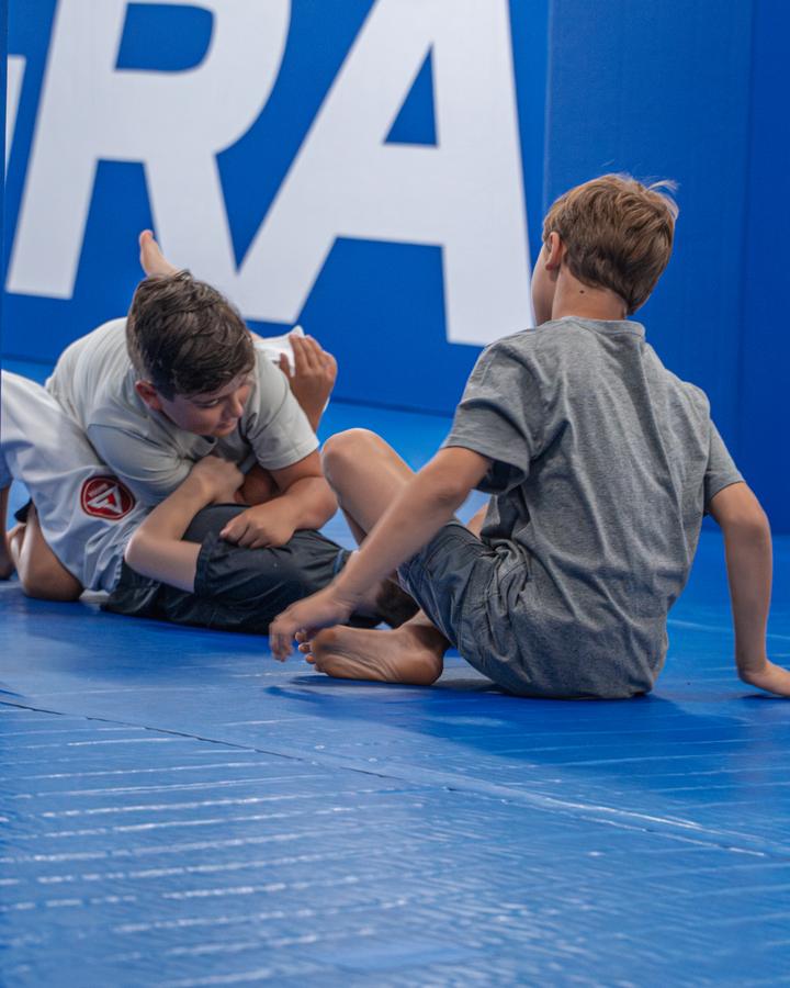 Two boys practising a technique in everyday clothes