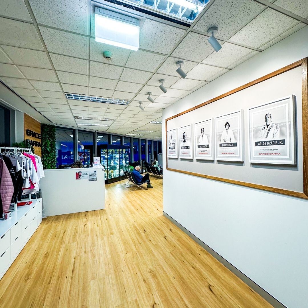 Gracie Barra Sydney entrance featuring legacy wall with photos of Carlos Gracie Sr. and Carlos Gracie Jr.