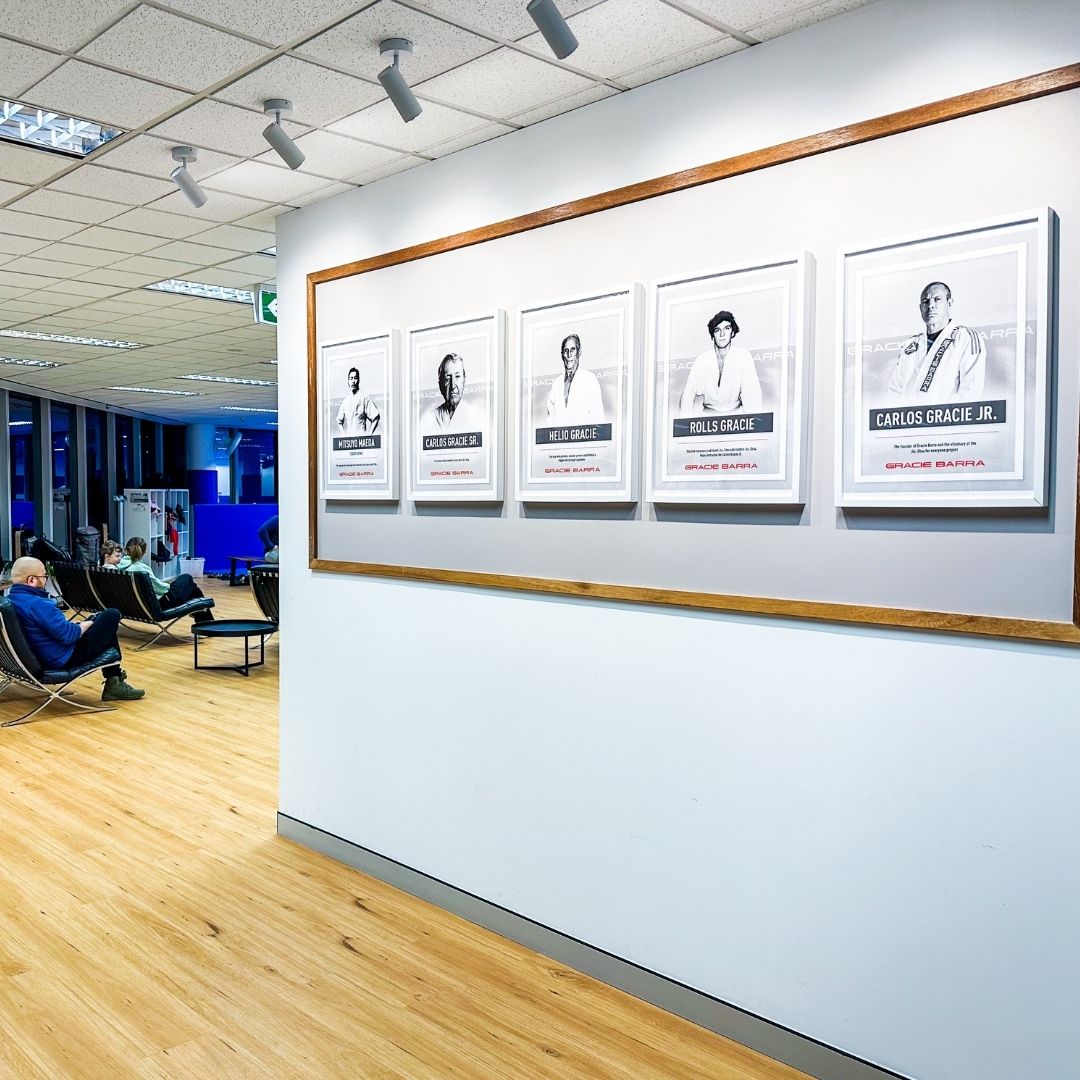 Gracie Barra Sydney entrance featuring legacy wall with photos of Carlos Gracie Sr. and Carlos Gracie Jr.