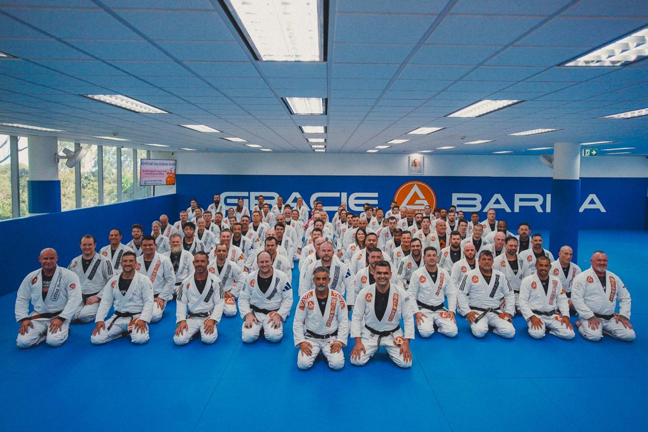Group photo of black belts and students at Gracie Barra HQ Sydney during Black Belt Day NSW 2025, all wearing Gracie Barra uniforms and smiling on the mats.